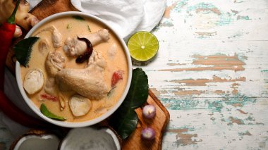 Tom Kha Gai 'nin üst görüntüsü, tavuklu hindistan cevizi sütü çorbası, tahta masada fotokopi alanı olan Tayland yemeği.