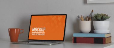 Ofis malzemeleri ve kırpma yolu ile boş ekran bilgisayarı ile modaya uygun çalışma alanının yakın görüntüsü 