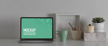 Beyaz masa üzerinde dizüstü bilgisayar ve ofis malzemeleri ile rahat çalışma alanının yakın görüntüsü, kırpma yolu