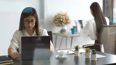 Ofis malzemeleriyle çalışan kadın ofis çalışanının cam penceresinden bakın.