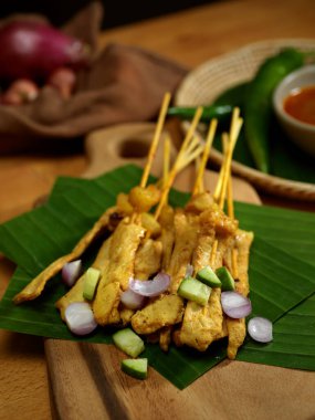 Fıstık soslu salatalık ve soğanlı ızgara domuz satay (Moo Satay).