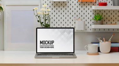 Masaya dizüstü bilgisayar, kitap, kırtasiye, kopya alanı ve çiçek döşenmiş modern çalışma tablosu, kırpma yolu