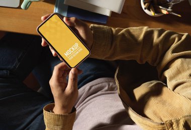 Ofiste otururken akıllı telefon kullanan erkeklerin üst görünümü, kırpma yolunu içerir