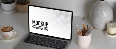 Bilgisayarın, kırtasiyenin ve dekorasyonun ev ofisinin çalışma odasındaki kırpma yolunun kesilmiş görüntüsü.