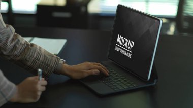 Ofis masasında dijital tabletle çalışan kadın elinin yan görünümü, kırpma yolunu içerir