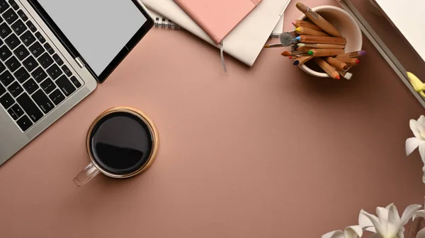 Top view of workspace with laptop, coffee cup, stationery and copy space on the table