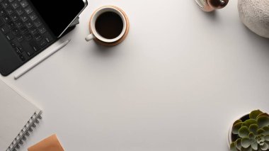 Fotokopi alanı, kahve fincanı ve malzemelerle dolu beyaz masa.