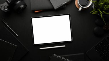 Ana ofis odasında tabletli, malzemeli ve dekorasyonlu siyah masanın üst görünümü, kırpma yolunu içerir