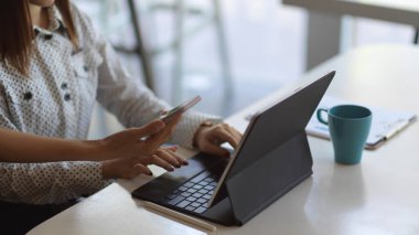 Projelerine akıllı telefon ve tabletle danışmanlık yapan iş insanlarının yan görünümü