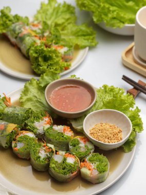 Soslu Vietnam böreği ve yemek masasında sebze. 