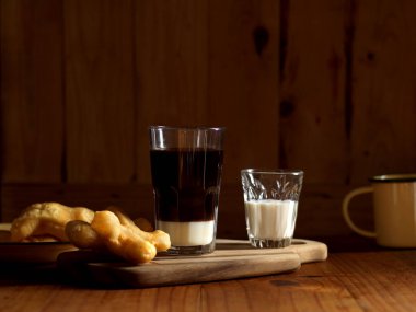 Kahve ve ahşap masada kızarmış hamur çubuklarıyla Tayland usulü kahvaltıyı yakından izleyin. 