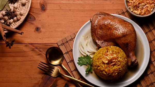 木製のテーブルの上にスパイスや刃物でマリネしたおいしい鶏のビリヤニのトップビュー — ストック写真
