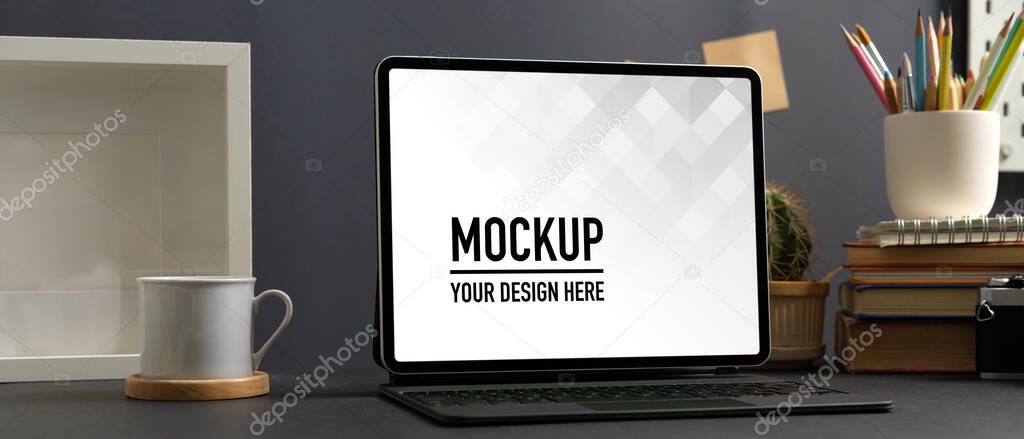 Cropped shot of worktable with laptop, stationery, camera and mock up frame in home office, clipping path 