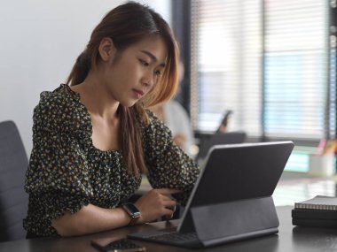Toplantı odasında dijital tabletle çalışan iş kadınının yan görüntüsü