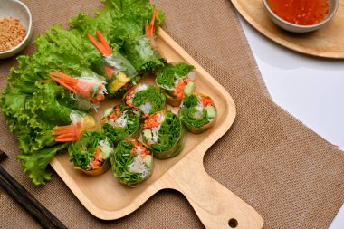 Vietnam börekleri ahşap tepside sos ile servis ediliyor. 