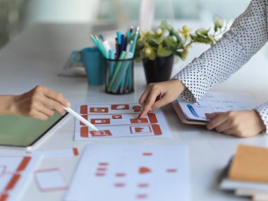 Proje üzerinde çalışan iki UI geliştiricisinin kağıt ve tabletle yaptıkları görüşmenin yan görünümü