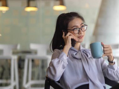 Ofiste kahve molası verirken iş kadınının telefonda konuştuğu görüntüyü kapat.