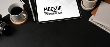 Çalışma alanının en üst görünümü tablet, defter, kamera, kahve fincanı ve siyah masadaki boşluğu kopyala