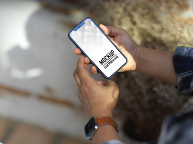 Bahçede dinlenirken akıllı telefon kullanan erkek elinin kırpılmış görüntüsü, kırpma yolunu da içerir