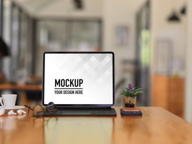 Dijital tabletli, aksesuarlı, gözlüklü ve saksılı ahşap masa resimleri.