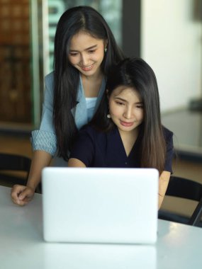 Modern ofis odasında yeni personeli eğiten nazik yöneticinin portreleri.