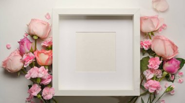 Çerçevenin üst görüntüsü ve beyaz masaya süslenmiş pembe çiçek