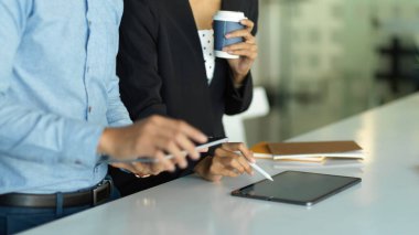 Toplantı masasında tabletlerle çalışan iş adamlarının ellerine yakından bakın.
