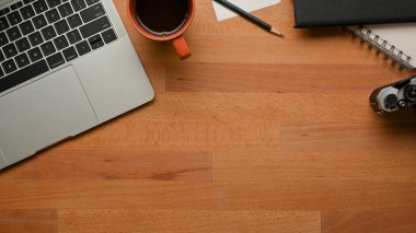 Çalışma alanının üst görüntüsü laptop, kırtasiye, kahve fincanı ve ofis odasında kopya alanı