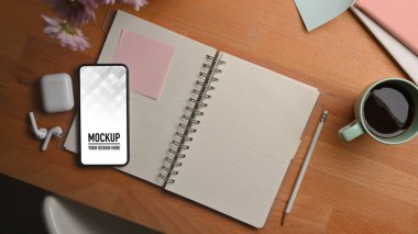 Akıllı telefon, not defteri, kulaklık ve kahve fincanının bulunduğu en iyi çalışma alanı.