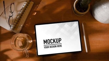 Dijital tablet, kahve fincanı, not defterleri ve kırtasiye malzemesi, kırpma yolu ile en iyi çalışma görünümü