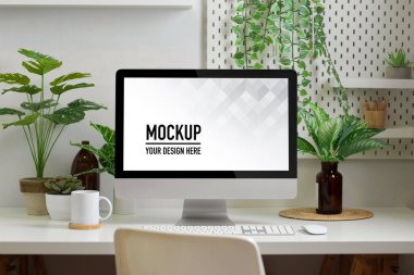 Biyofili çalışma odasında bilgisayar, malzeme, dekorasyon ve fabrikalarla dolu.