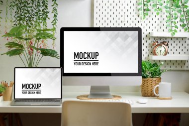 Ana ofis odasındaki biyofili çalışma alanını bilgisayar, dizüstü bilgisayar, malzeme ve bitki eviyle kapatın.