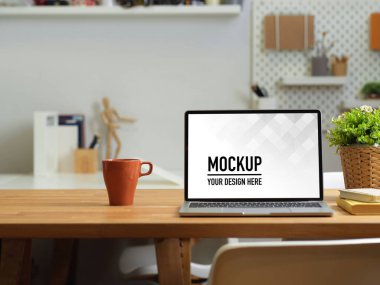 Ofis masasını laptoplu, kupalı, kırtasiyeli ve ahşap masadaki malzemelerle kapat.