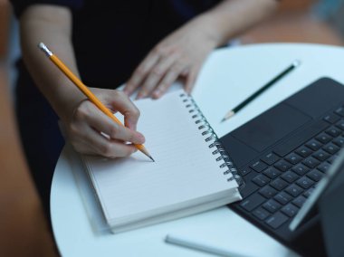 Dijital tabletle çalışırken boş not defterine kadın eli yazma görüntüsünü kapat