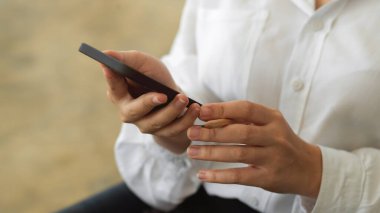 Ofiste akıllı telefon kullanan kadınların ellerini kapat.