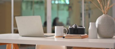 Dizüstü bilgisayar, kamera, kırtasiye malzemesi ve seramik vazo ile oturma odasında kullanılabilir.