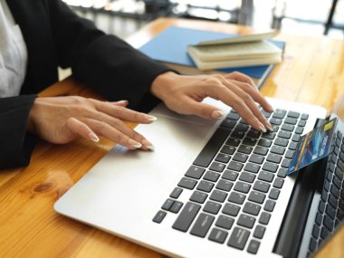 Bilgisayarda online ödemeye kredi kartıyla yazı yazan kadınların yan görünümü 