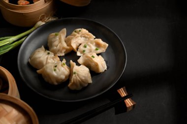 Tabak ve bambu buharlı Dimsum hamur köftesi ve kopyalama alanı ile masanın kırpılmış görüntüsü. 