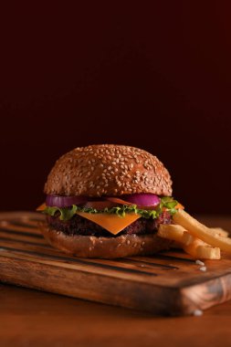 Masadaki ahşap tepside ızgara biftek ve patates kızartması. 