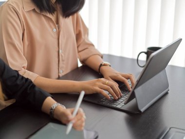 Toplantı odasında iş arkadaşının yanında otururken, erkek ellerinin tablet klavyeye yazı yazmasını kapat