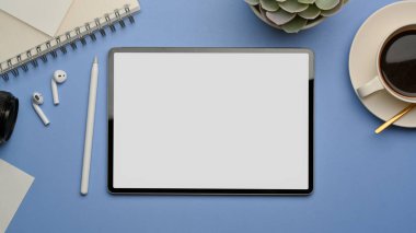 Ofis odasında dijital tablet, kahve fincanı, kırtasiye ve aksesuarlı en iyi çalışma alanı görüntüsü