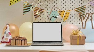 Doğum günü süslemeleri, dizüstü bilgisayarı, pasta ve hediye ile masayı kapat, kırpma yolu