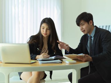 Dizüstü bilgisayardan bilgi ararken projelerini tartışan iki iş adamının portreleri