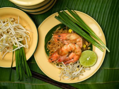 Tayland yemekleri, karidesli Tayland eriştesi, limon, fasulye ve muz yapraklı Tayland frenk soğanı.