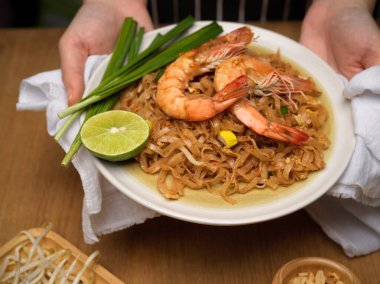 Bir tabak karıştırılmış Tayland eriştesi, limonlu, fasulyeli ve soğanlı, Pad Thai soslu.