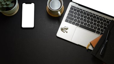 Dizüstü bilgisayarı, kırtasiyesi, akıllı telefonu, kahve fincanı ve fotokopi temposu olan yaratıcı düz çalışma alanı.