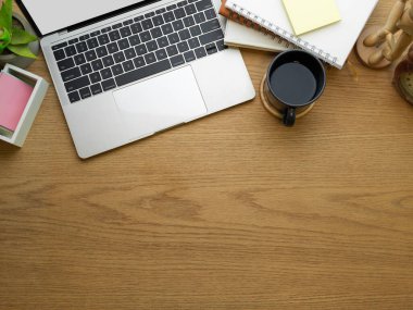 Dizüstü bilgisayarı, kahve fincanı, kırtasiye malzemesi ve fotokopi odası olan yaratıcı çalışma alanının en üst görünümü