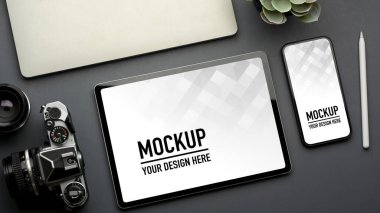 Akıllı telefon, tablet, kamera ve dizüstü bilgisayarlı yaratıcı düz çalışma alanının üst görünümü gri masada, kırpma yolu
