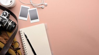 Not defteri, kalem, kamera, fotoğraf çerçevesi, çanta ve fotokopi alanı olan pembe tablo üst görünümü, sahne oluşturma 