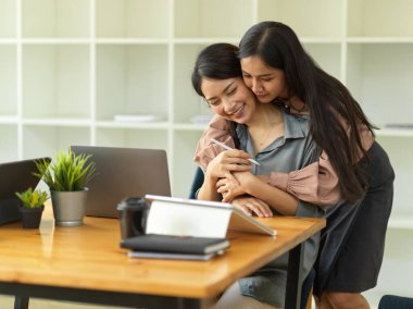 Ofiste çalışırken sarılan iki kadın ofis çalışanının portreleri, mutlu arkadaşlar, arkadaşlık. 